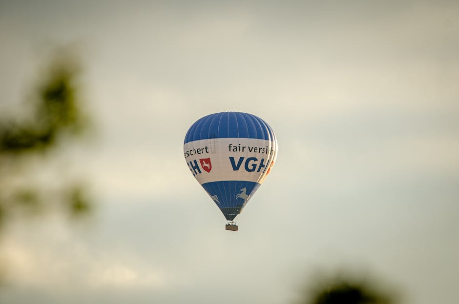 A blue hot air balloon with text flying in a clear sky, creating a serene travel scene
