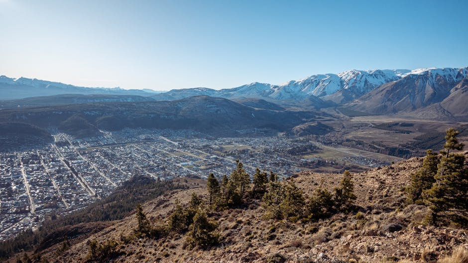 Breathtaking panoramic view of Esquel, Argentina, with snow-capped mountains and clear blue skies