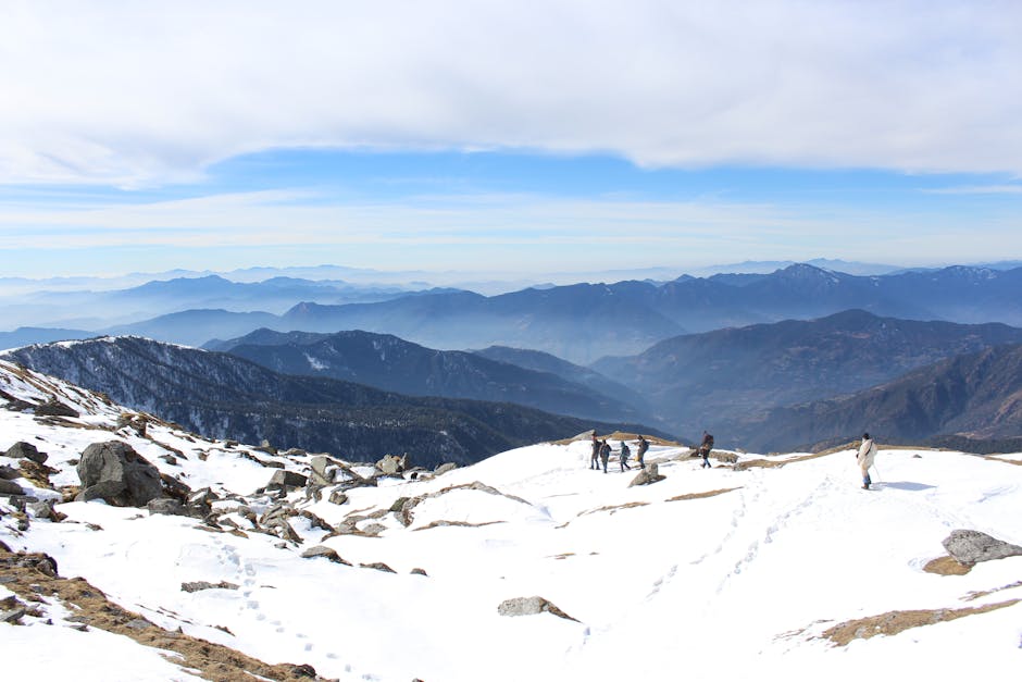 Group of trekkers exploring the snowy Himalayas with scenic mountain views in the distance.